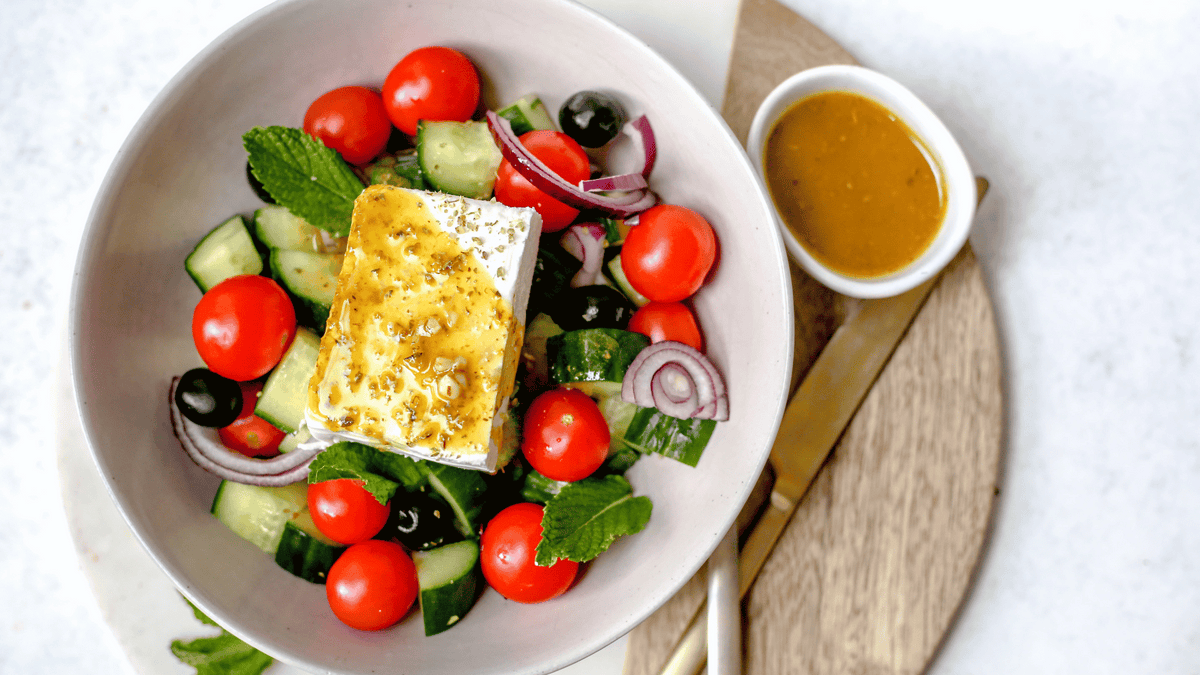 greek salad with avocado oil dressing on table