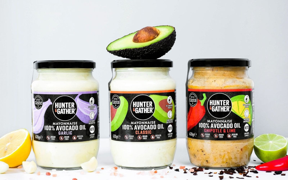 three jars of mayo surrounded by avocados