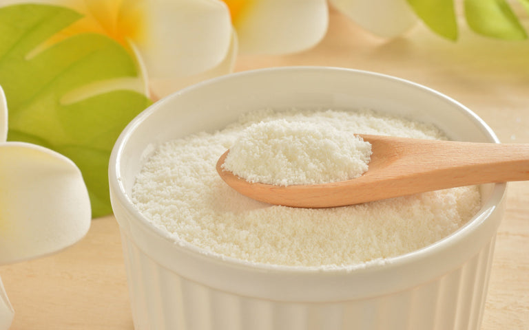 keto collagen: Collagen powder in a white ramekin with a wooden spoon on top of it