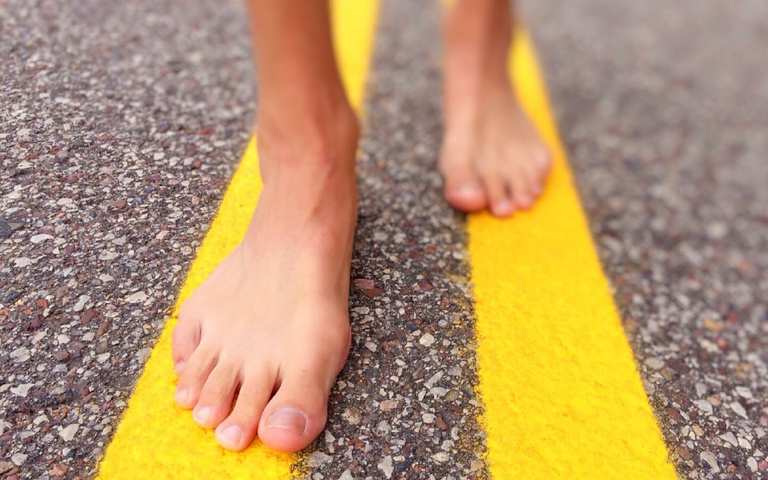 barefoot walking along yellow lines