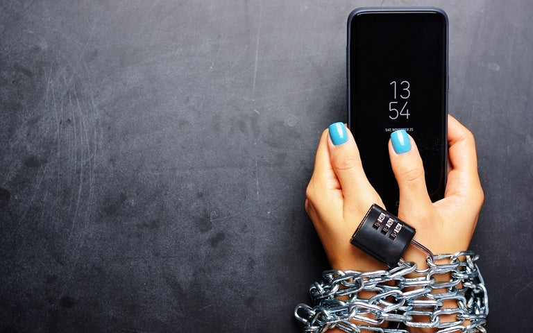 hands bound with chains and a mobile phone