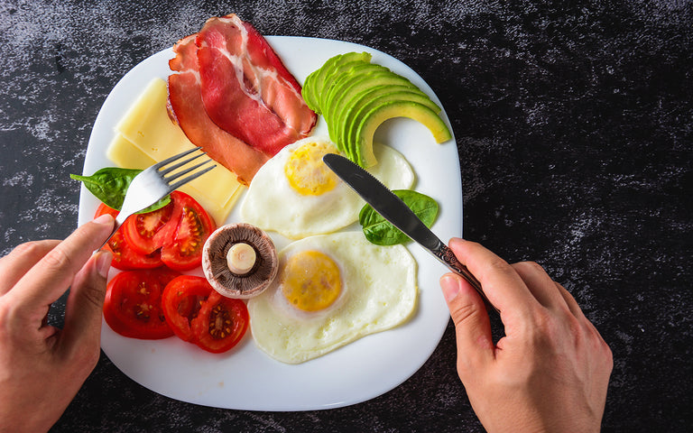 is keto safe: Man holding a fork and a knife preparing to eat his keto breakfast