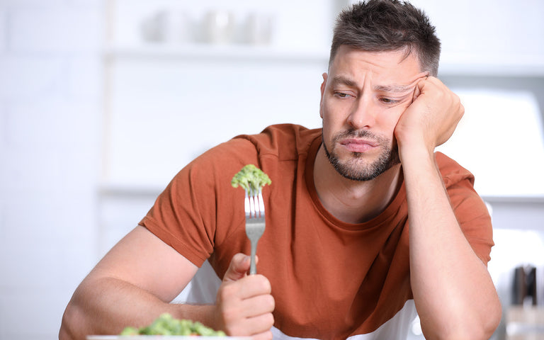 Game changers debunked: Unhappy man eating broccoli