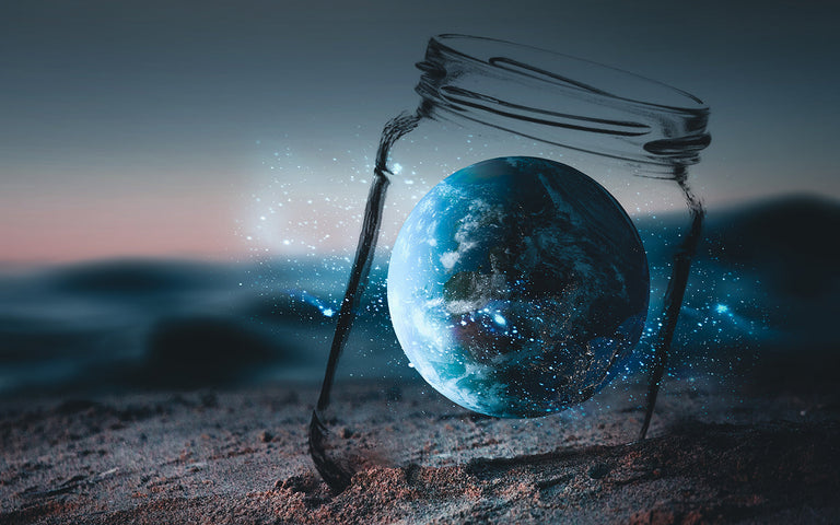 glass jar with world inside on a beach