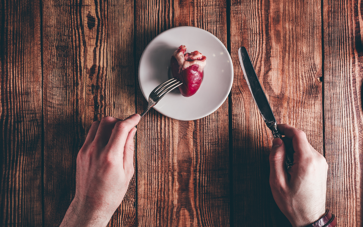 Raw lambs heart on wooden background