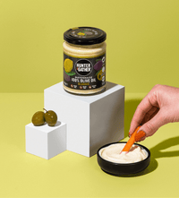 Dipping Carrot Into Classic Olive Oil Mayonnaise
